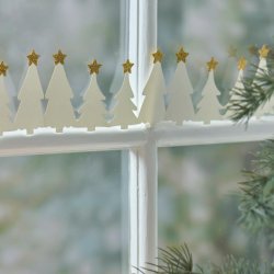 Papirjuletr�er med guldstjerner st�ende i vindueskarm som julepynt