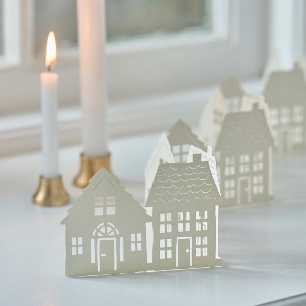 Sm� papirhuse p� r�kke i vindueskarm med levende lys som juledekoration